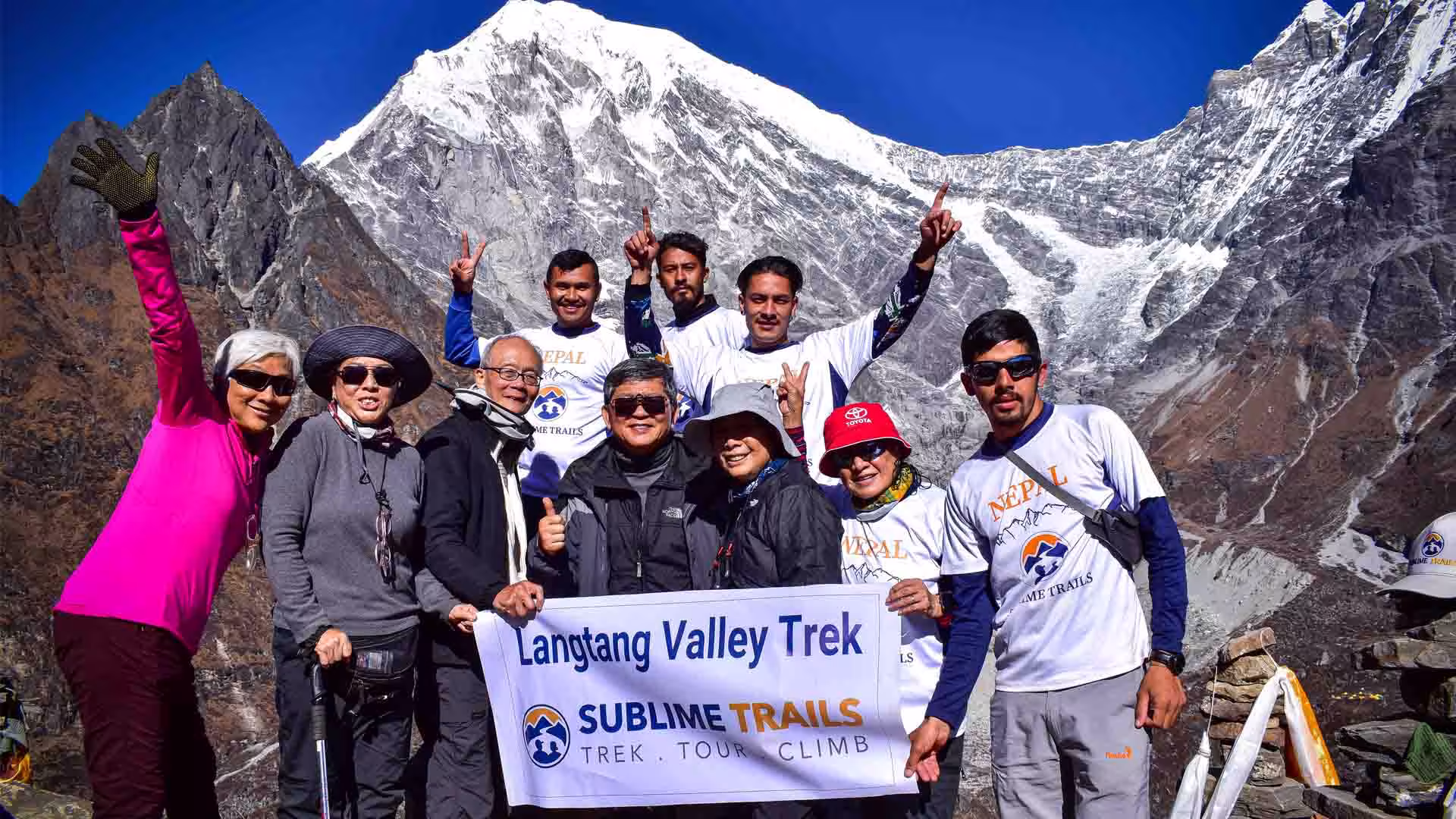 Trekkers and guide holding a Sublime Trails banner during the Langtang Valley Trek