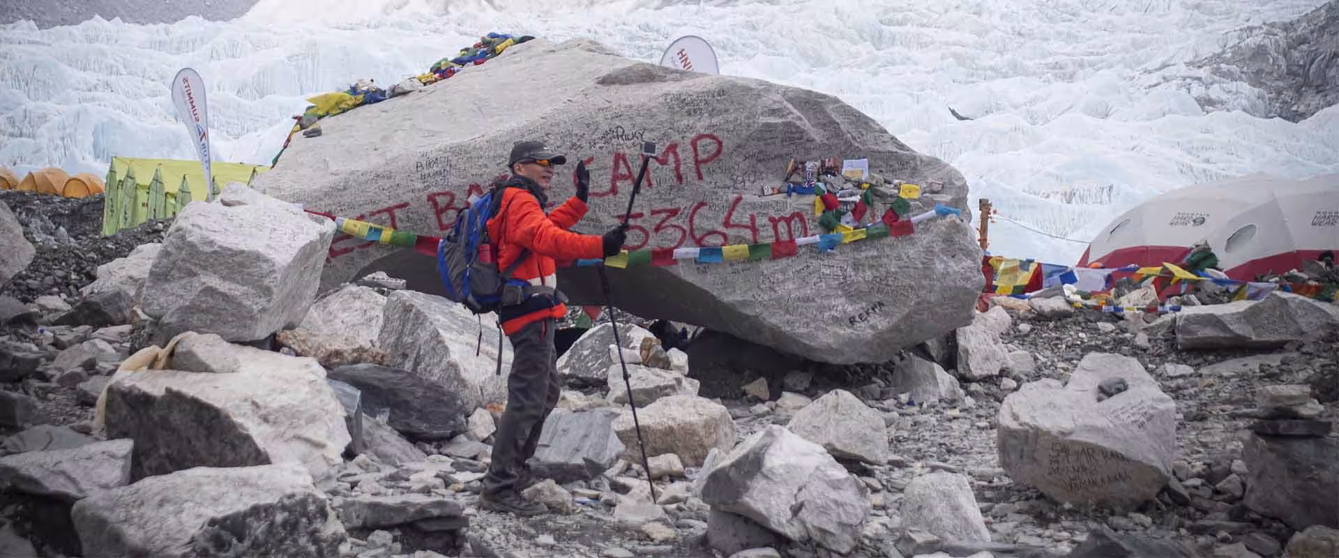 Trekker at the Everest Base Camp elevation marker at 5,364 metres