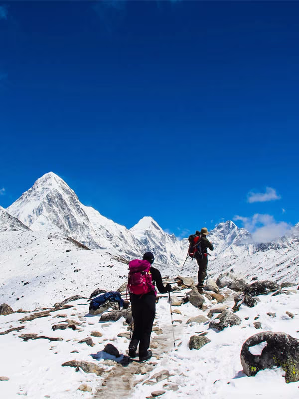Trekkers hiking across a snowy mountain trail during the Everest Three High Passes Trek in Nepal