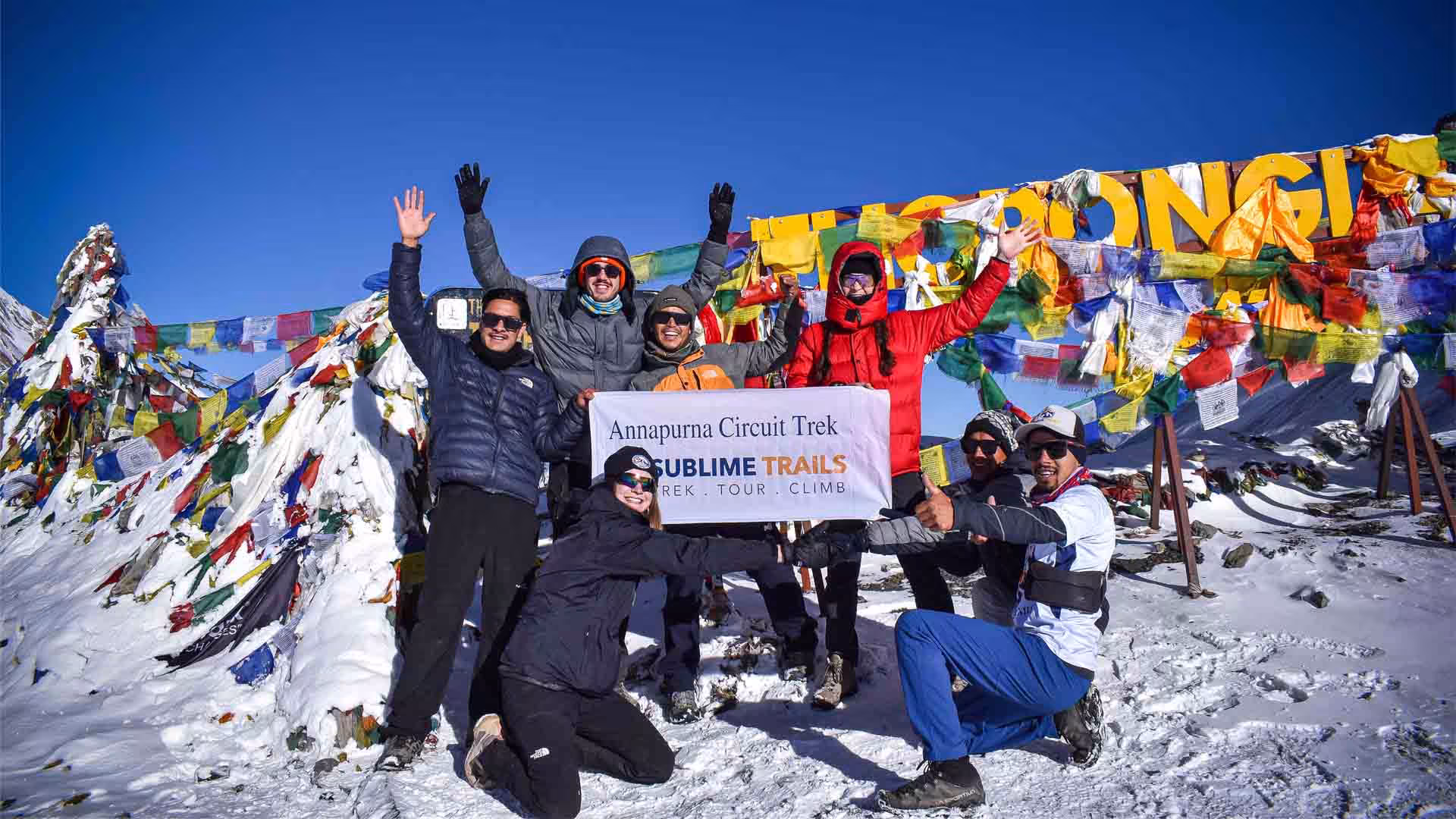 Clients and guides celebrating at Thorong La Pass during the Annapurna Circuit Trek in Nepal