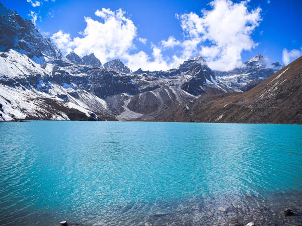 Turquoise Gokyo Lake, a breathtaking highlight of the Everest Three High Passes Trek, surrounded by towering Himalayan peaks and pristine alpine scenery.