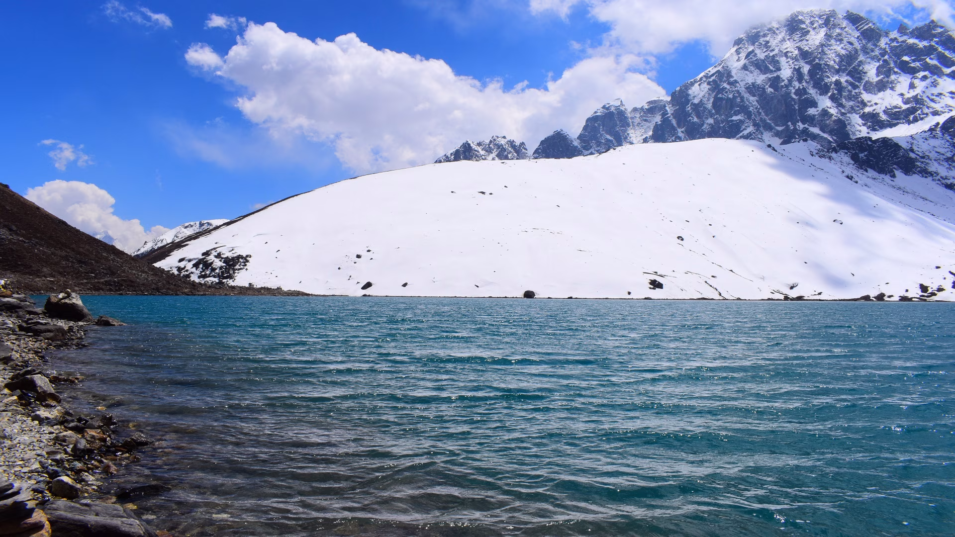 Turquoise Gokyo Lake with snow-covered Himalayan peaks on the Everest Base Camp via Gokyo Lakes and Cho La Pass Trek in Nepal.