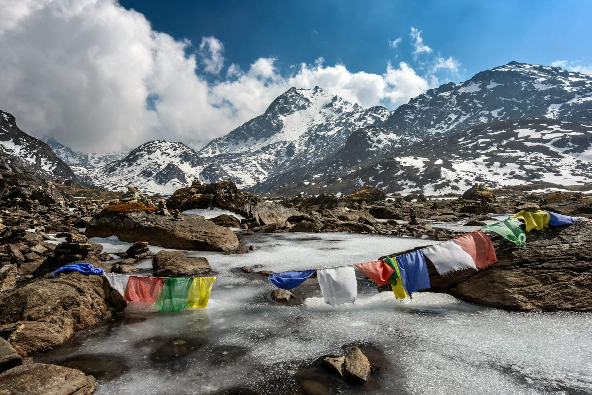 Frozen stream in Langtang with snow-covered peaks in the background.