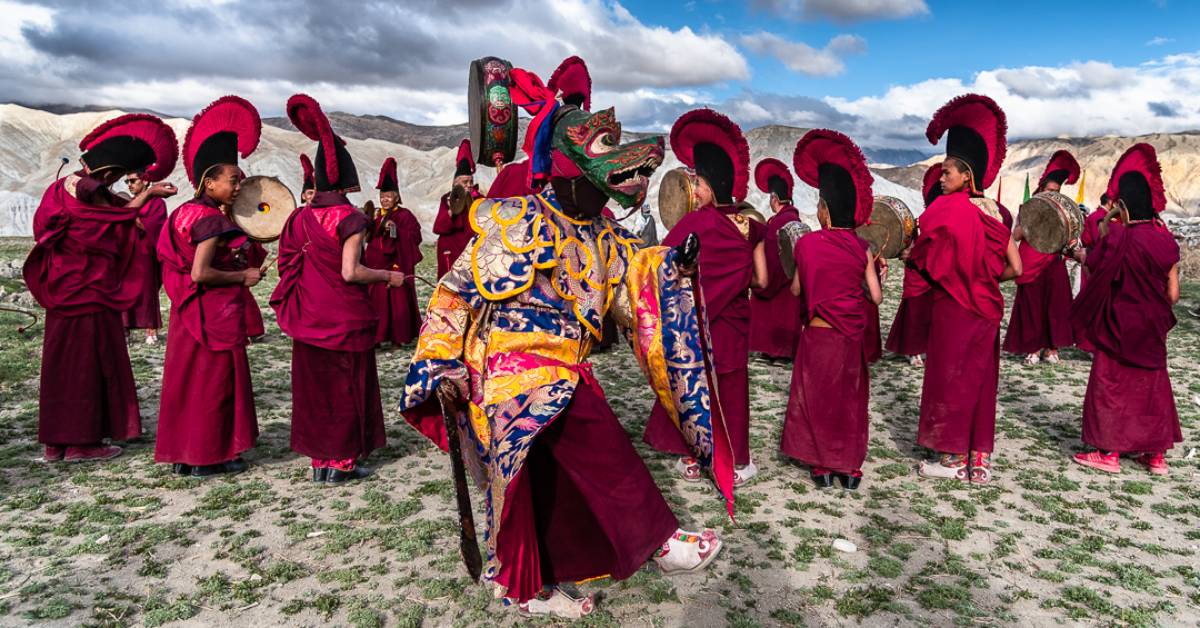 Masked monk with other monks in preparation for Tiji festival