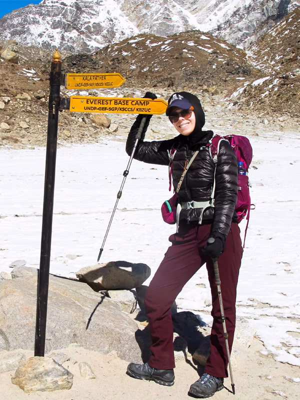 Woman at the Everest Base Camp and Kala Patthar signpost during the Everest Base Camp Trek with Helicopter Return in Nepal.