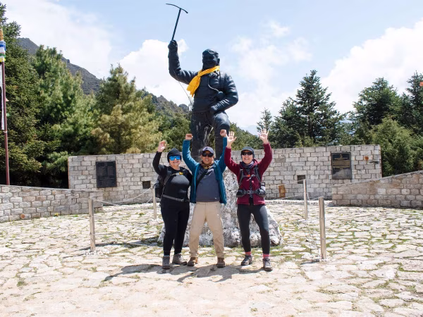 Trekkers And Guide Having Fun Infront Of Statue
