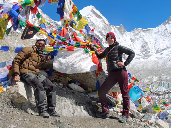 Guide and trekker taking photo at popular Everest Base Camp stone.