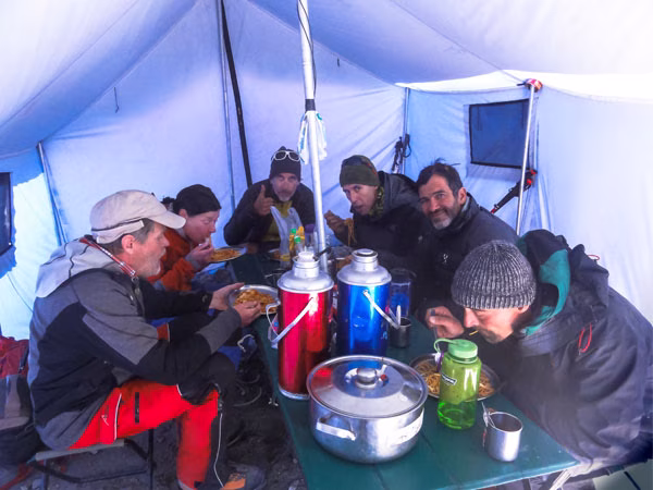 Trekkers enjoying food while experiencing Everest life in a tent.